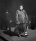 USA: A wealthy merchant followed by his bodyguard. San Francisco Chinatown, c. 1900